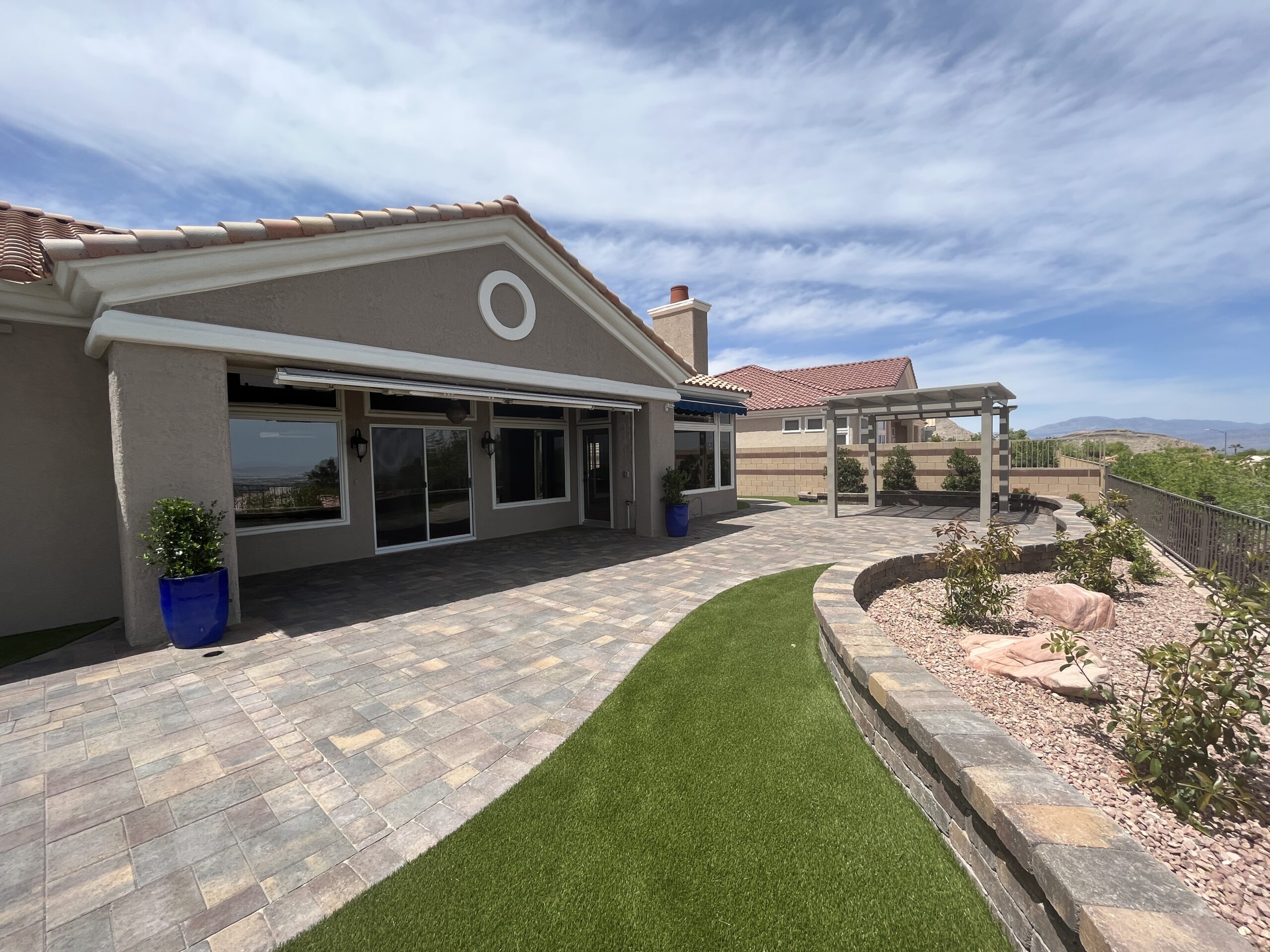A patio with grass and a pergola in the middle of it. A patio with grass and a pergola in the middle of it.