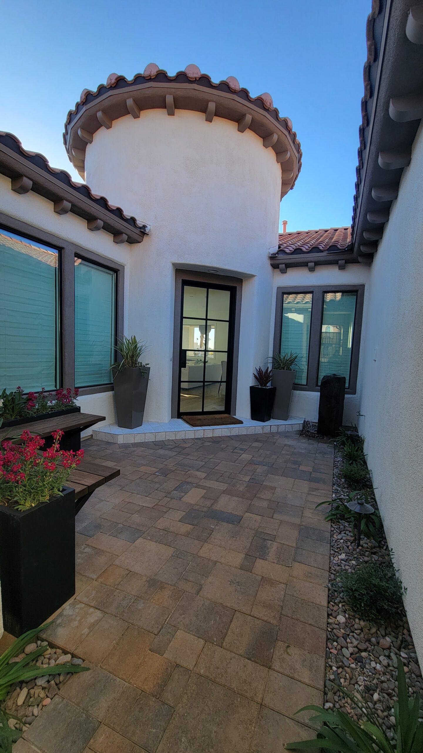 A patio with potted plants and a door. A patio with potted plants and a door.
