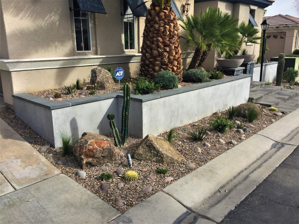 A plant bed with plants and rocks on the side of the road. A plant bed with plants and rocks on the side of the road.