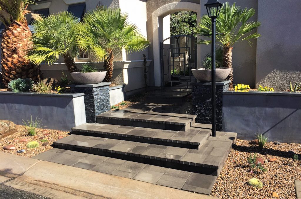A front entrance with steps and planters. A front entrance with steps and planters.